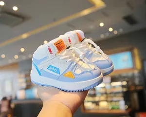 Close-up of stylish blue and white high-top children sneakers with orange accents