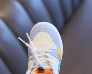 Close-up of the toe box and lacing system on a blue and white kids high-top sneaker