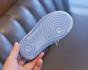 Detail view of light blue children's sneaker sole with anti-slip concentric patterns.