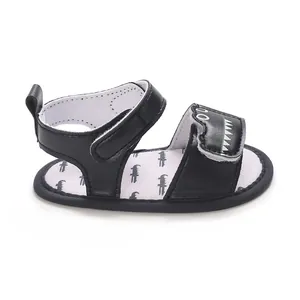 Detail of black infant sandal with cartoon dinosaur teeth pattern on strap