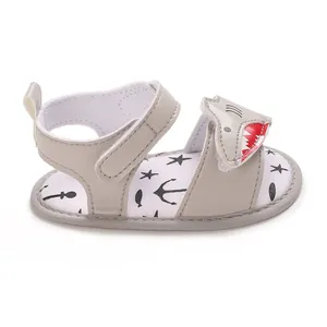 Grey baby sandal with a fun shark cartoon design and soft, nautical-printed sole