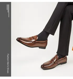 Primer plano profesional de mocasines de cuero marrón usados por un modelo en traje de oficina
