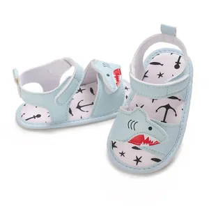 Close-up of baby walking sandals with cute shark design and soft sole in light blue.