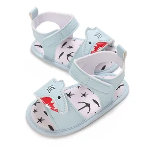 Detail view of light blue baby sandals featuring a cartoon shark and nautical print