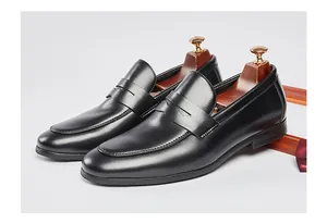 Vista detallada de mocasines Penny clásicos de cuero negro para hombre con hormas