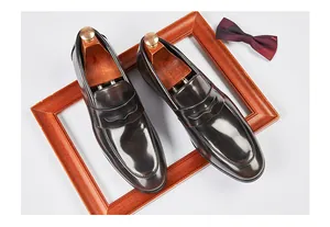 Vista superior de mocasines clásicos de cuero pulido marrón en un marco de madera