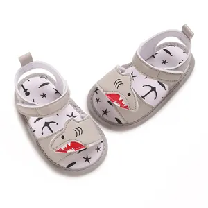 Detail shot of the cartoon shark motif on grey infant sandals with soft walking soles