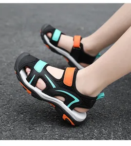 Side view of child wearing breathable closed-toe sports sandals on asphalt ground