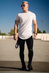 Full body view of a white slim-fit athletic t-shirt on a muscular male model outdoors