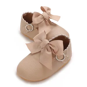 Gros plan de chaussures de princesse pour bébé avec un grand nœud et du cuir PU souple