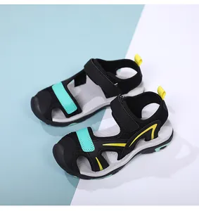 Detail view of black and turquoise closed-toe sport sandals with hook-and-loop straps for boys.