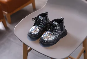 Détail de bottines noires pour filles avec motifs de cœurs irisés et fermeture éclair