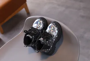 Gros plan détaillé de bottines Martin pour enfants avec motif de cœur holographique brillant