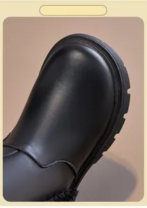 Close-up detail of black leather child's Martin boot toe box with durable thick sole