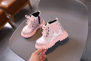 Gros plan de bottines Martin roses pailletées pour filles avec semelles antidérapantes
