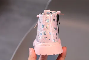 Détail de bottes roses pour tout-petits avec motifs cœurs argentés et fermeture éclair