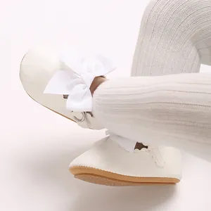 Vue détaillée de chaussures de princesse pour bébé blanches avec un grand nœud