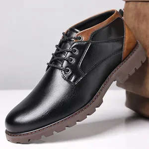 Detail of black and brown men's lace-up low-top work boots with lug sole
