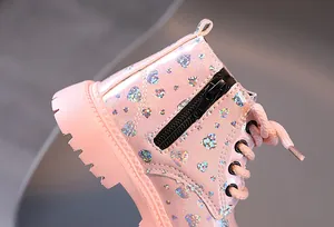Gros plan de bottines roses pour enfants avec motifs de cœurs brillants et fermeture