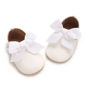 Détail de haute qualité de chaussures bébé en PU blanc avec un grand nœud élégant.