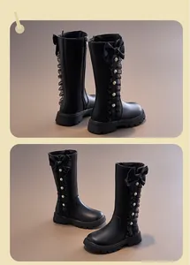 Close-up showing the bow, ruffle, and pearl details on these black girls' tall boots.