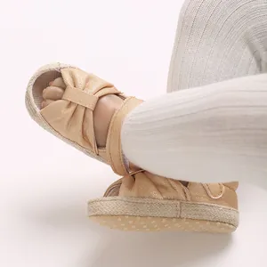 Close-up of baby shimmer bow sandals with soft anti-slip dotted sole
