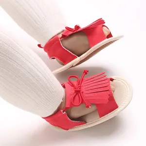Detailaufnahme roter Babysandalen für Mädchen mit Fransen und weicher, flexibler Sohle
