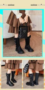 Detail view of girl's black high-top boots with bow accents and elegant pearl studs