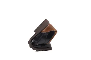 Flexible men's low-top Martin work boots showing sole pliability in a studio shot.