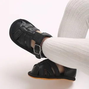 Close-up of black woven leather baby sandals with soft rubber sole for infant boys