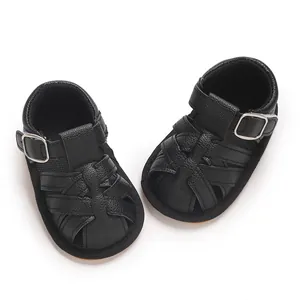 Detailed macro view showing the texture of black faux leather baby sandals with woven design