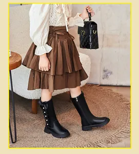 Detail view of black girl's knee-high boots with side bow and elegant ruffle design