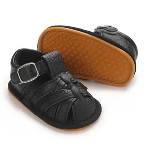 Close-up of black baby boy sandals featuring breathable woven leather and star-patterned soft soles.