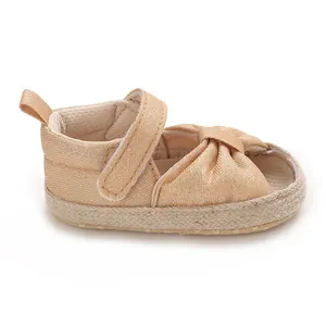 Detailed side view of champagne gold baby soft sole sandals with knotted fabric toe