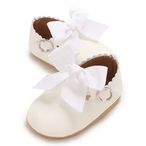 Macro view of white PU leather baby girl shoes featuring elegant large bow details