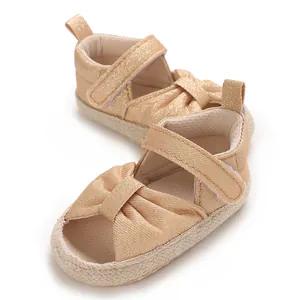 Close-up detail of champagne gold glitter infant sandals with soft sole and bow