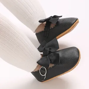 Détail de chaussures de princesse pour bébé en cuir PU noir avec un grand nœud