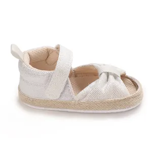 Close-up of baby white woven sandal with velcro strap and espadrille sole details
