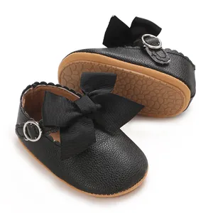 Vue rapprochée des chaussures de princesse pour bébé en similicuir noir avec nœud
