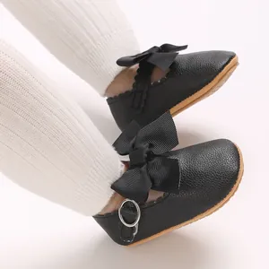 Macro detail of elegant black PU leather baby girl princess shoes with a bow decoration