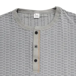 Detailansicht des atmungsaktiven grauen Henley-T-Shirts mit Strukturstoff und Knöpfen
