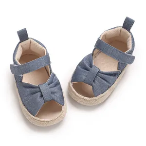 Close-up of baby denim bow sandals with soft woven sole for infants 0-1 year old