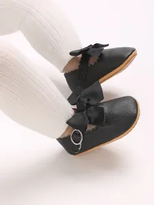 Close-up view of black PU leather baby Mary Jane shoes featuring elegant bow details