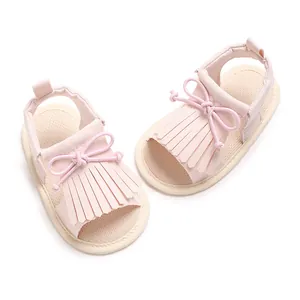 Nahaufnahme von rosa Lauflernschuhen für Mädchen mit Fransen und Schleifen.