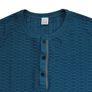 Detail eines blauen Herren-Henley-Shirts mit strukturiertem Stoff und Knopfleiste