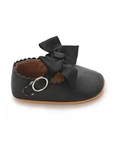 Detailed close-up of a black baby princess walking shoe with oversized bow and buckle