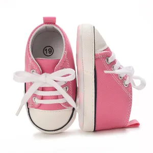 Side and front macro view of pink infant canvas sneakers with white laces