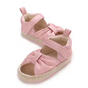 Detailed view of pink glitter baby sandals featuring soft braided soles and velcro straps