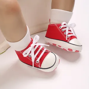 Close-up of red canvas baby sneakers with white laces for infants aged 0-1 year old