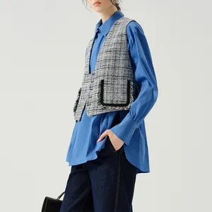 High-end Japanese shell buttons featured on a stylish grey tweed vest layered over blue shirt.